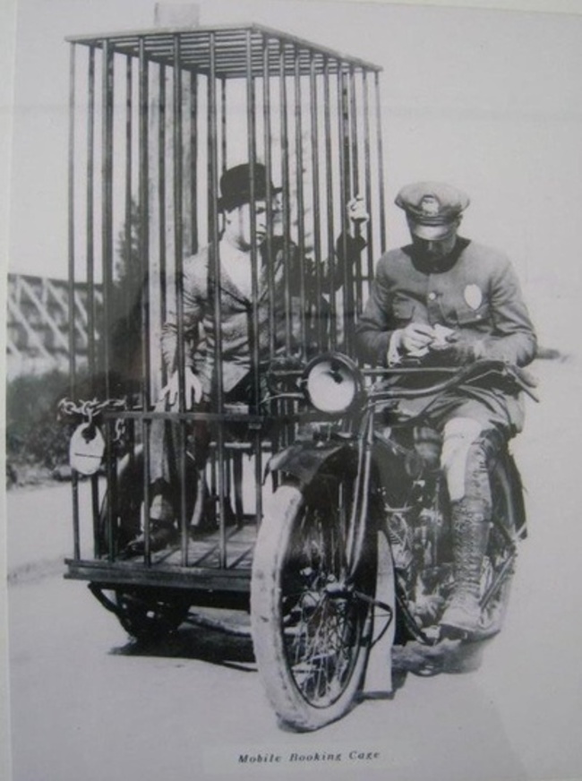 19.-A-police-officer-on-a-Harley-and-an-old-fashioned-mobile-holding-cell.-1921