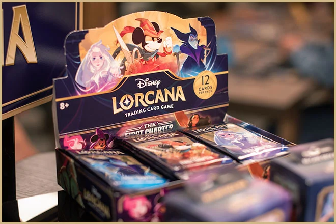 Krabice s balíčky karetní hry Disney Lorcana na prodejním stojanu.