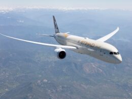 Letadlo společnosti Etihad Airways letí nad krajinou s horami v pozadí.