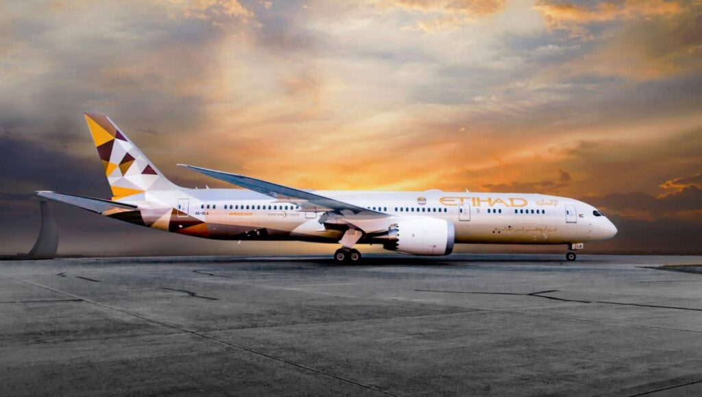 Letadlo společnosti Etihad Airways na letištní ploše při západu slunce.
